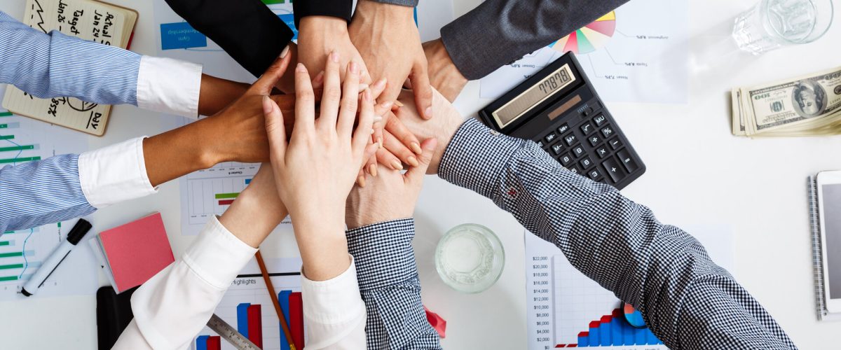 Picture of businessmen's hands on white table with documents, coffee and drafts